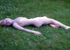 Busty teen lying naked in the grass