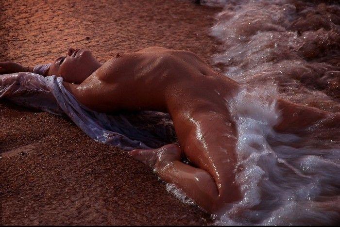 Hot dish sitting on the beach and letting the waves caress her beautiful body
