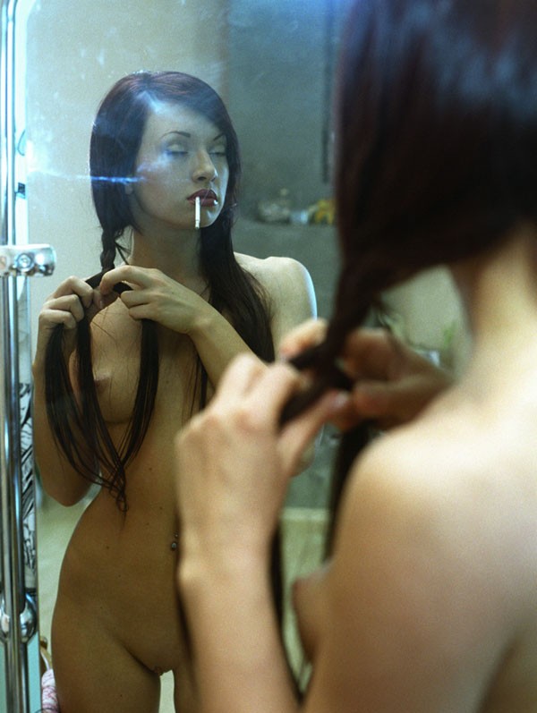 Hot smoking brunette babe carresing in the mirror her beautiful hair
